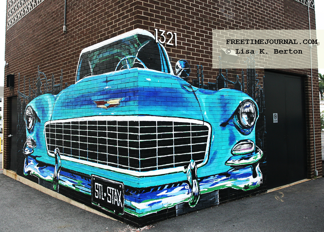mural of a vintage car painted on the corners of a brick building